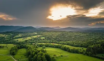Panorama zielonych wzgórz i gór Beskidu Niskiego w świetle zachodzącego słońca