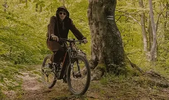 Promocja zawodów MTB na leśnej ścieżce między drzewami.