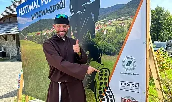 Założyciel Stowarzyszenia Przekrocz Granice promujący baner wydarzenia sportowego